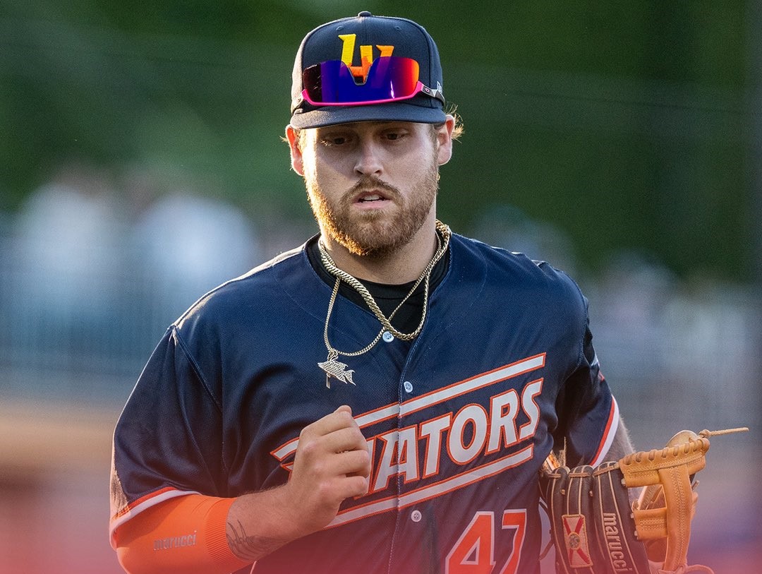 Baseball player in a navy jersey with orange accents, number 47, wearing a cap with mirrored sunglasses and a glove on his left hand.