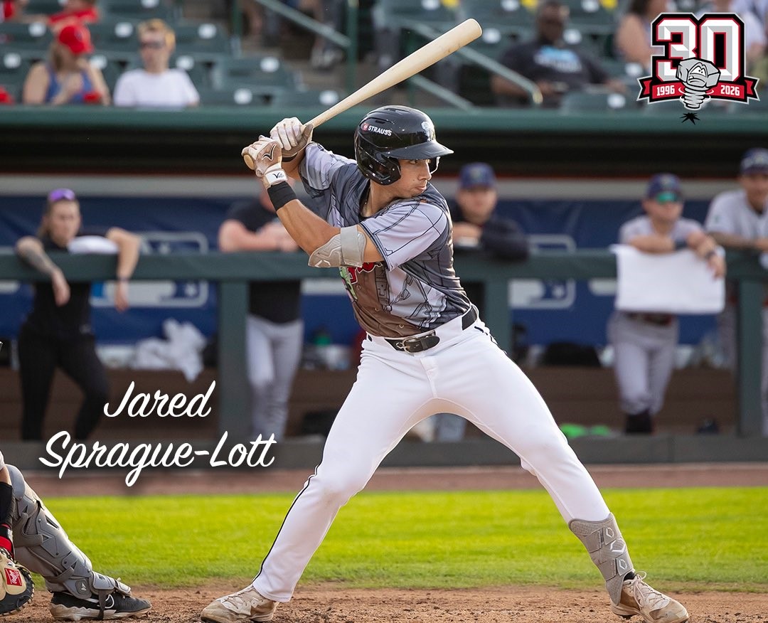 Baseball player Jared Sprague-Lott at bat during a game, wearing a helmet and gray uniform.