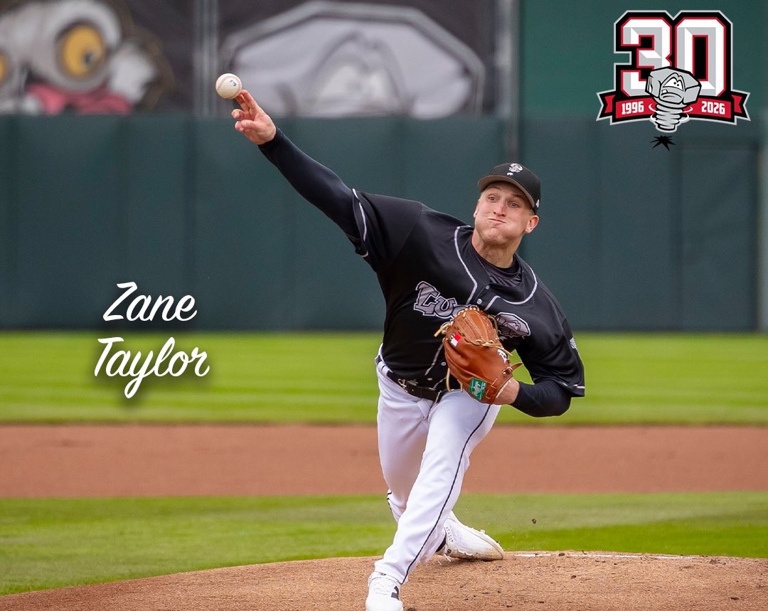 Baseball pitcher in a black uniform delivering a pitch from the mound, with 'Zane Taylor' text on the left and a 30th anniversary logo in the top-right corner.