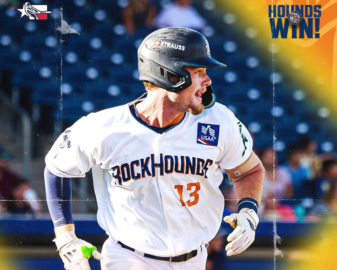 RockHounds baseball player wearing #13 in white uniform, helmet, running on the field with stadium seats behind and a "HOUNDS WIN!" graphic in the top right.