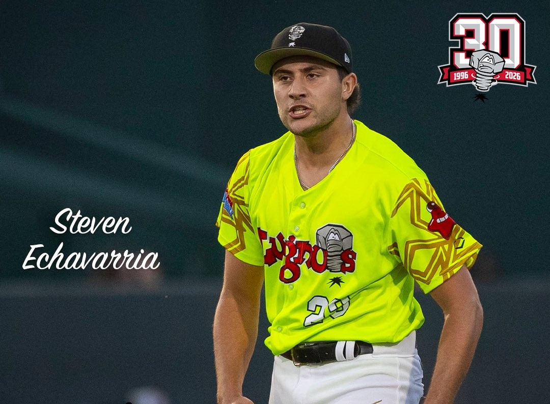 Baseball player Steven Echavarria in a bright neon-yellow jersey with number 29 on the field, with a 30th-anniversary logo in the top-right corner.